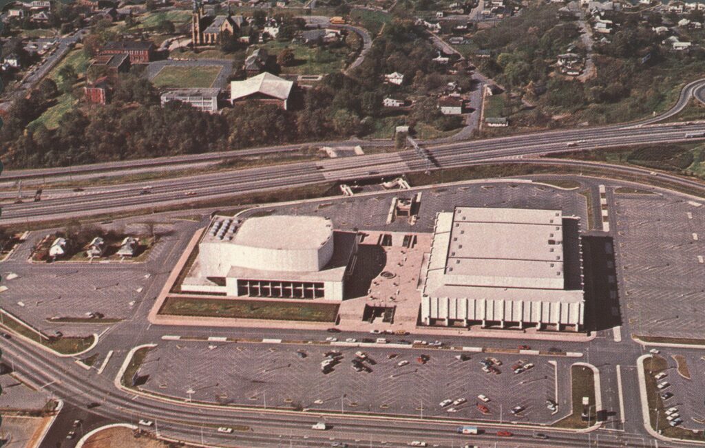 An aerial photo of the Civic Center with 3 houses visibly still standing with the parking lot built around them